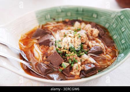 Frische Reisnudeln mit scharfer Schweinesuppe in einer Schüssel nördlich der thailändischen Küche. Thailändisches Essen ist Kanom Jeen Nam Ngeaw Stockfoto