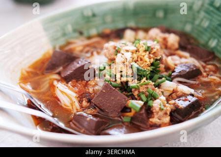 Schließen Sie frische Reisnudeln mit scharfer Schweinesuppe in einer Schüssel nördlich der thailändischen Küche. Thailändisches Essen ist Kanom Jeen Nam Ngeaw Stockfoto