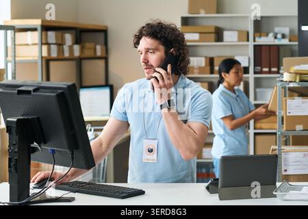 Man verwaltet Anrufe zur Auftragsabholung im Versandzentrum Stockfoto