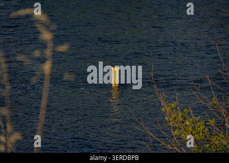 Gelbe Navigationsoje schwimmt auf plätscherndem Fluss Stockfoto