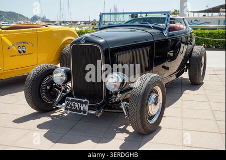 Dreiviertelansicht eines klassischen schwarzen Ford Roadster aus dem Jahr 1932 mit verchromten Scheinwerfern, offenen Rädern und einer freiliegenden Vorderachse, die bei einem sunn geparkt ist Stockfoto