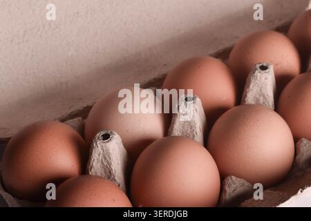 Eine Nahaufnahme eines Kartons mit rohen, natürlichen braunen Hühnereiern. Stockfoto