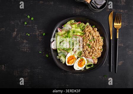 Gesunde Frühstücksschale mit Haferbrei-Salat und weich gekochten Eiern. Draufsicht Stockfoto