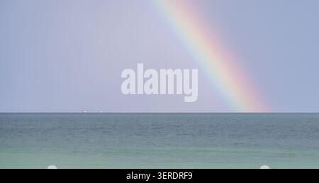 Regenbogen über das ruhige Wasser des bodensees mit weit entfernten Booten am Horizont Stockfoto