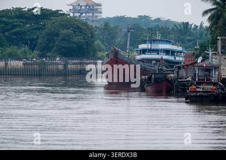 Pekanbaru, Indonesien - 28. September 2025: Traditionelle Holzfrachter legten entlang des trüben braunen Siak River an Stockfoto