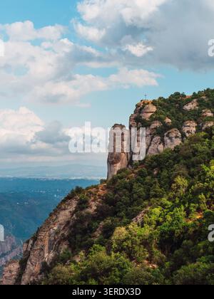 Dieses Stockfoto zeigt einen atemberaubenden Blick von oben auf einem der berühmtesten Berge Spaniens, Montserrat. Das Bild zeigt schroffe Klippen, die mit einem Hauch verziert sind Stockfoto