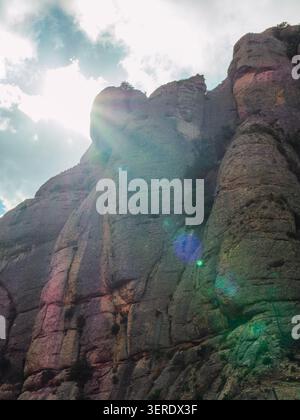 Eine lebhafte Felsformation, die in goldenes Sonnenlicht getaucht ist und von der rauen Oberfläche reflektiert wird. Stockfoto