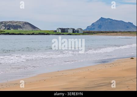 Búðir an der Südküste der Halbinsel Snæfellsnes, Westinsel, von einem Sandstrand mit Búðakirkja und Bergen aus gesehen. Stockfoto