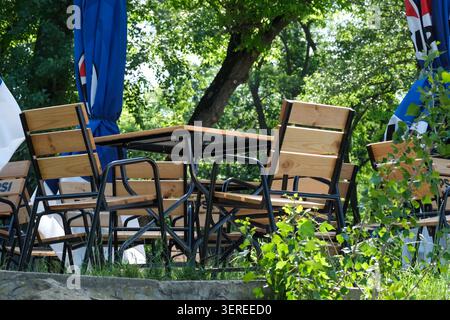 Holzstühle und -Tische in der Natur, perfekt für einen sonnigen Tag. Kiew, Ukraine. Juni 2026 Stockfoto