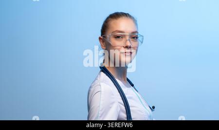 Junge Ärztin mit Schutzbrille und Stethoskop Stockfoto