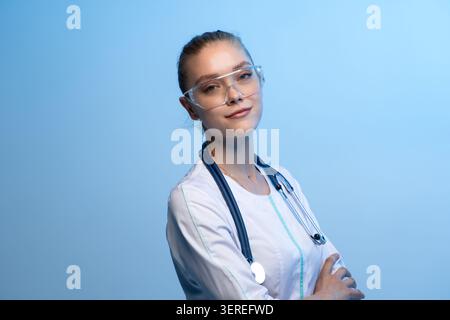 Junge Ärztin mit Schutzbrille und Stethoskop Stockfoto
