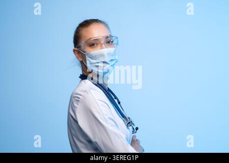 Weibliche Ärztin trägt Gesichtsmaske und Schutzbrille, arbeitet in der Medizin und im Gesundheitswesen Stockfoto