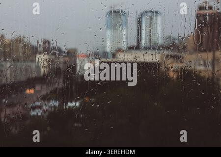 Wassertropfen auf eine Fensterglasoberfläche mit Kondensation. Hintergrund der nassen Glasstruktur. Wassertropfen auf einem Fensterglas bei regnerischem Wetter. Stockfoto
