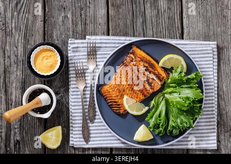 Lachsfilet gegrilltes Speisenfoto mit Zitrone und Salat auf Teller, Nahaufnahme Fischsteak Rezeptkonzept für Restaurantmenü, nicht AI Gattungen Stockfoto