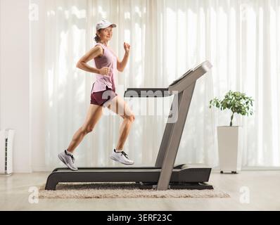 Fitte, reife Frau, die zu Hause auf einem Laufband läuft Stockfoto