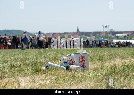 Neuhausen, Deutschland. Juni 2026. Bierdosen werden am Tag der Ankunft auf einem Feld verstreut. Im Hintergrund stehen zahlreiche Festivalbesucher am Eingang zum Campingplatz des Southside Festivals. Das Southside Festival in Neuhausen ist eines der größten Open-Air-Festivals in Deutschland·. Es beginnt offiziell am Freitag. Quelle: Silas Stein/dpa/Alamy Live News Stockfoto