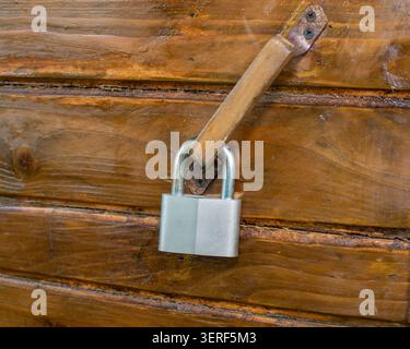 Metallschloss an einer rustikalen Holztür Stockfoto