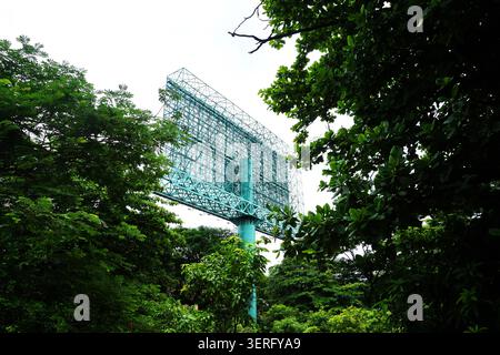 Große leere Stahlplakate, umgeben von üppig grünen Bäumen in einem Stadtpark Stockfoto