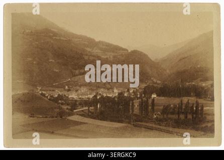 Ein Pressefoto zeigt eine allgemeine Ansicht von Bedous in den Pyrenäen-Atlantiques, die das Dorf in einer Bergtallandschaft mit umliegenden Hügeln und ländlichen Gebäuden zeigt, die ein kompaktes Siedlungsmuster bilden. Stockfoto