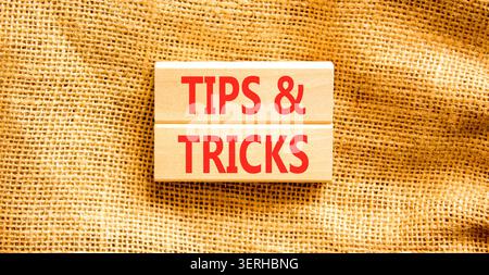 Symbol für Tipps und Tricks. Konzeptwörter Tipps und Tricks auf schönen Holzblöcken. Schöner Leinwandhintergrund. Geschäftliche Tipps und Tricks motivieren Stockfoto