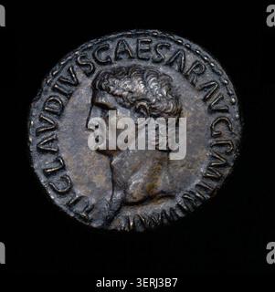 Eine römische Münze unter Claudius I. präsentiert kaiserliche Titulatur in lateinischer Inschrift, die die frühe kaiserliche Währungsgewalt und das römische numismatische Design von 41 n. Chr. widerspiegelt. Stockfoto