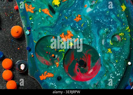 Kreative abstrakte Kunstwerke mit türkisfarbenen, fließenden Texturen, schwebenden kreisförmigen Formen und lebendigen Farbakzenten. Perfekt für naturwissenschaftlich inspirierte Grafiken Stockfoto