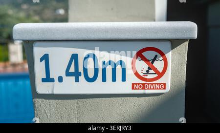 Warnschild am Poolrand in Agia Effimia, Kefalonia, Griechenland, das darauf hinweist, dass Tauchen verboten ist und eine Tiefe von 1,40 m vorliegt Stockfoto