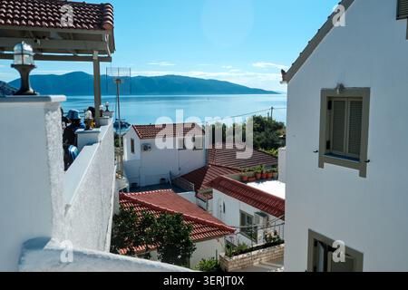 Küsten Dorf Agia Effimia, Kefalonia, Griechenland, mit weißen Häusern und roten Dächern, mit Blick auf das Meer Stockfoto