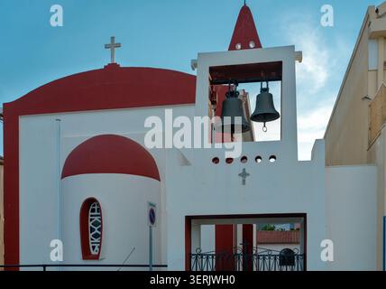 Traditionelle griechische Kirche mit rot-weißer Fassade und Glockenturm in Agia Effimia, Kefalonia, Griechenland Stockfoto