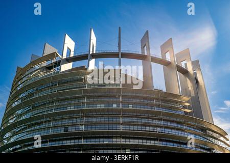 Die Nahaufnahme mit niedrigem Winkel verstärkt die kreisförmige und futuristische Glasstruktur des Europäischen Parlaments. Große Metallsäulen und ein abgehängter Gang Stockfoto