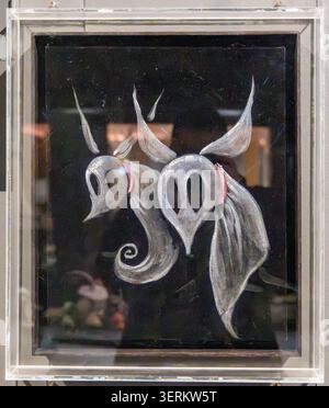 London, UK - 16. März 25: Gerahmte surreale Illustration mit zwei stilisierten Kreaturenköpfen, die in der Ausstellung World of Tim Burton gezeigt werden. Stockfoto
