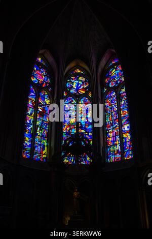 Abstrakte Buntglasfenster mit Kronleuchter-Silhouette in der Kathedrale Notre-Dame von Reims, Reims, Grand Est, Frankreich. Stockfoto