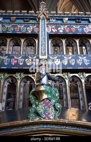 Nahaufnahme der gemalten Heraldik und geschnitzten Chorständer in Westminster Abbey, London, England. Stockfoto