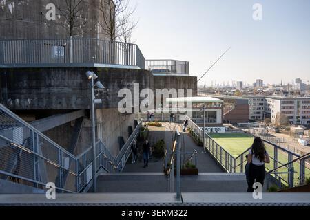 Hamburg, Deutschland - 28. Februar 25: Blick von der St. Pauli Bunkerterrasse in Hamburg, mit Blick auf ein Fußballfeld und Besucher auf dem Gehweg. Stockfoto