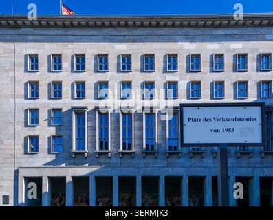 Straßenschild Platz des Volksaufstandes von 1953 mit dem historischen Gebäude des Bundesministeriums für Finanzen in Berlin. Platz Des Völkeraufstands. Stockfoto