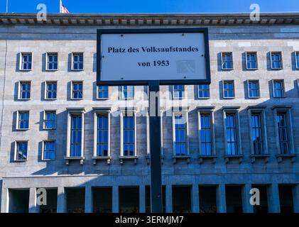 Straßenschild Platz des Volksaufstandes von 1953 mit dem historischen Gebäude des Bundesministeriums für Finanzen in Berlin. Platz Des Völkeraufstands. Stockfoto