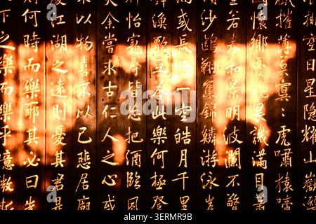 Chinesische Schrift auf Holzbrettern Sonnenschattenkontrast Stockfoto