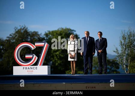Die französische First Lady Brigitte Macron, Präsident Donald J. Trump und der französische Präsident Emmanuel Macron posieren während des G7-Gipfels am 16. Juni 2026 in Evian-les-Bains. Bild mit freundlicher Genehmigung des Weißen Hauses. Stockfoto