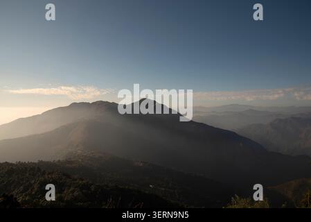 Sonnenstrahlen über majestätischen nebeligen Berggipfeln an Wolken enden in Mussoorie, Uttarakhand, Indien Stockfoto