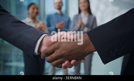Multiethnisches Geschäftsteam schüttelt im Büro die Hände. Zwei nicht erkennbare Männer Diversität Geschäftsleute schütteln Arme und grüßen mit Handschütteln drei Agenten Stockfoto