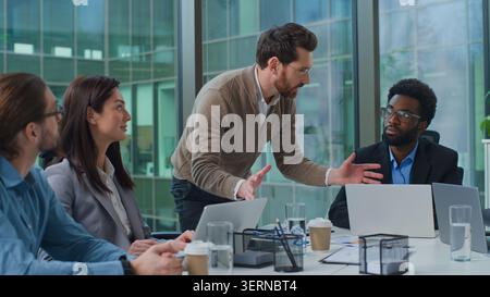 Kaukasischer Mann Boss stehend emotionale Talk erklärt Arbeitsaufgaben für multiethnische Unternehmensgruppen, Frauen und Männer, Geschäftsleuten Stockfoto