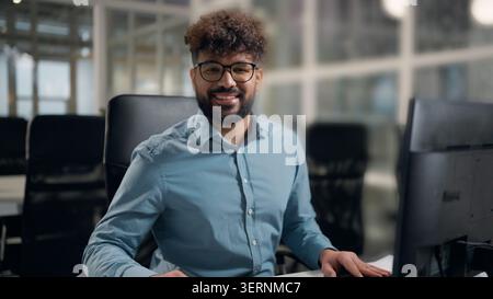 Arabischer Geschäftsmann arbeitet mit Computertechnologie lächelnd glücklich positiv Blick in die Kamera zufrieden motivierter erfolgreicher ethnischer Geschäftsmann Stockfoto