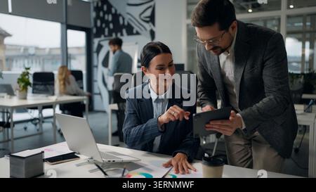 Kaukasische Geschäftsfrau Unternehmensleiter Boss Consulting Geschäftsmann Manager zeigt digitale Tablet-Daten und fragt Geschäftsmann und Geschäftsmann bei der Diskussion Stockfoto