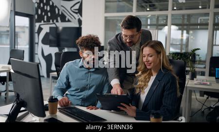 Multiethnische drei Geschäftskollegen Team bei Briefing Meeting über Papiere mit Ordner im Büro Kaukasier Mann mit digitalem Tablet mit Stockfoto