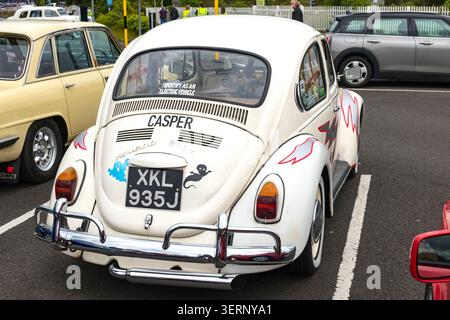 Rückansicht eines klassischen volkswagen Käfers und eines gelben Triumphes auf einem britischen Parkplatz Stockfoto
