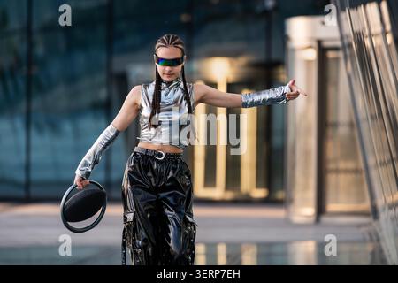 Stilvolle junge Frau in silberner futuristischer Kleidung Stockfoto