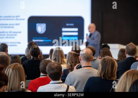 Geschäftskunden, die dem Referenten zuhören, konzentrierten sich auf Folienpräsentationen, Networking, Lernen und professionelles Engagement bei Unternehmensseminaren. Stockfoto
