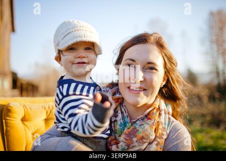 Glückliche Mutter und Kind lächeln draußen in die Kamera Stockfoto