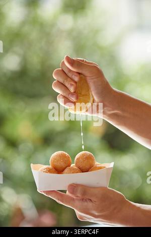 Koreanische süße Reis Donuts gebraten goldbraun in einer Metallschale und auf einem Tablett, Nahaufnahme Lebensmittelfotos auf einem warmen Hintergrund Stockfoto