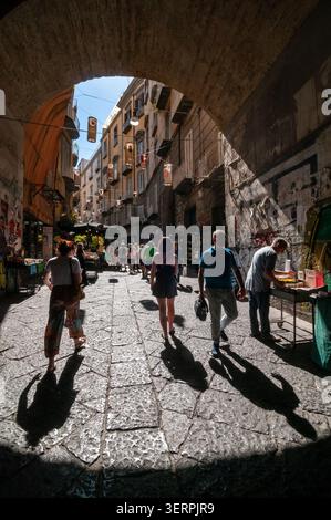 Blick von der Hinterleuchtung auf Port'Alba, die Straße der Bücher, vom Bogen des Eingangstors. Neapel, Italien Stockfoto